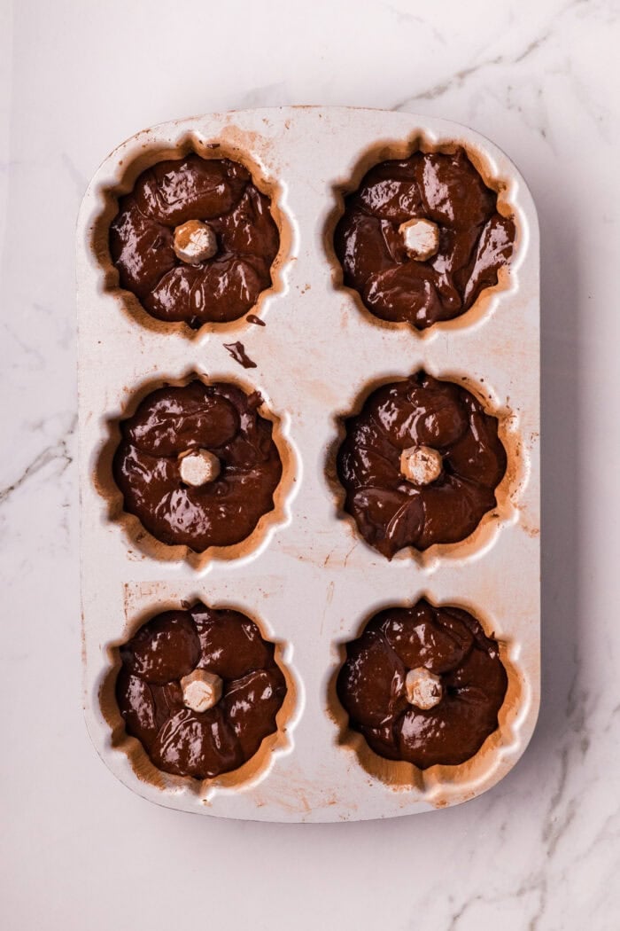 These Mini Chocolate Bundt Cakes offer a rich chocolate flavor and ultra-moist crumb in perfectly portioned, individual cakes. Chocolate bundt cake batter in a mini bundt pan