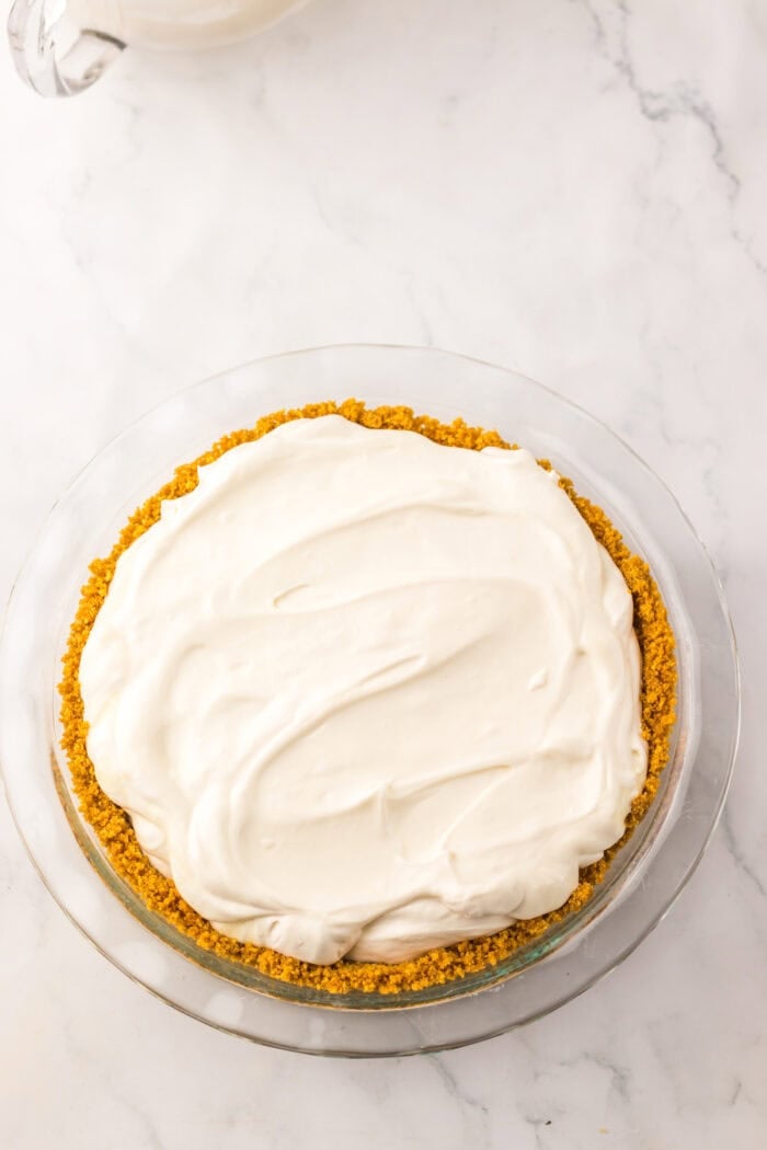Tangy and fruity, Strawberry Lemonade Pie features layers of creamy lemonade pie filling topped with strawberry swirl. Lemonade pie filling in a graham cracker crust