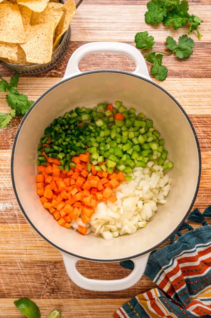 Black beans are simmered with warm, smoky spices and veggies in this Black Bean Soup recipe for an easy vegetarian dinner. Diced celery, carrots, onion, and jalapeno in a pot