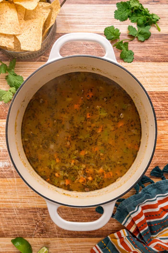 Black beans are simmered with warm, smoky spices and veggies in this Black Bean Soup recipe for an easy vegetarian dinner. Broth added to the pot of veggies