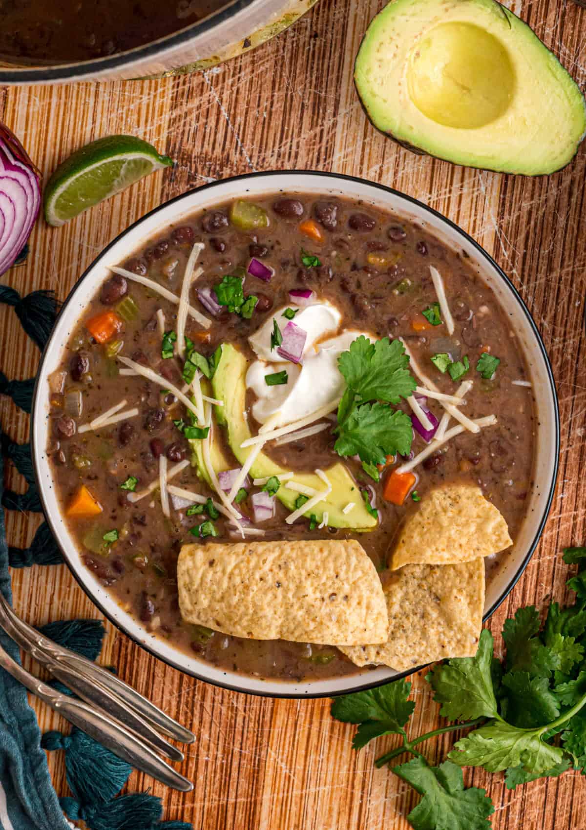 Black beans are simmered with warm, smoky spices and veggies in this Black Bean Soup recipe for an easy vegetarian dinner. The top of Black Bean Soup in a bowl