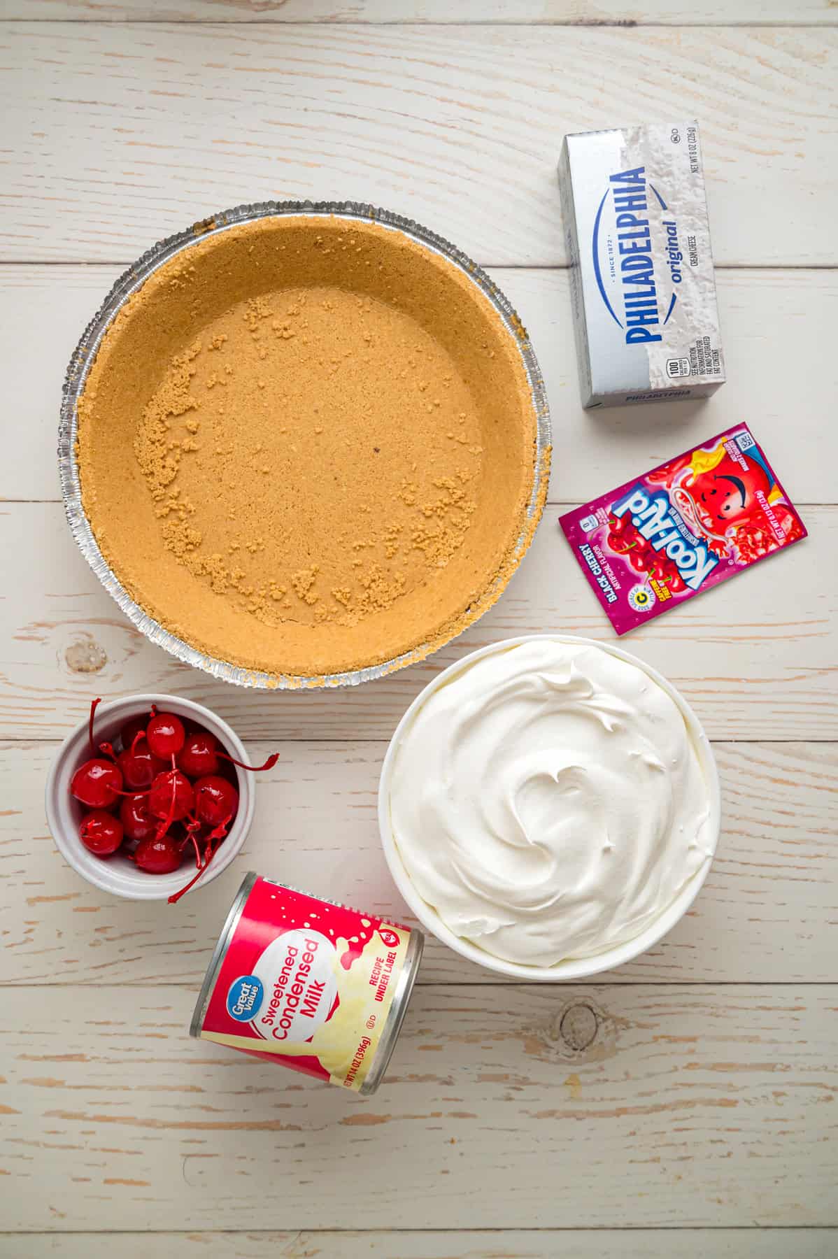 Made with cream cheese, sweetened condensed milk, and Kool Aid mix in a graham cracker crust, this No-Bake Kool Aid Pie is always a hit. Overhead view of ingredients needed to make Kool Aid Pie