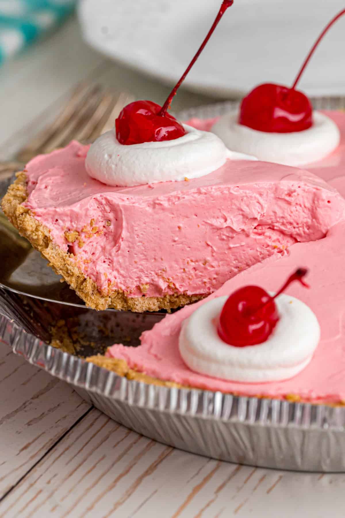 Made with cream cheese, sweetened condensed milk, and Kool Aid mix in a graham cracker crust, this No-Bake Kool Aid Pie is always a hit. No Bake Kool Aid Pie slice being lifted out of the pan