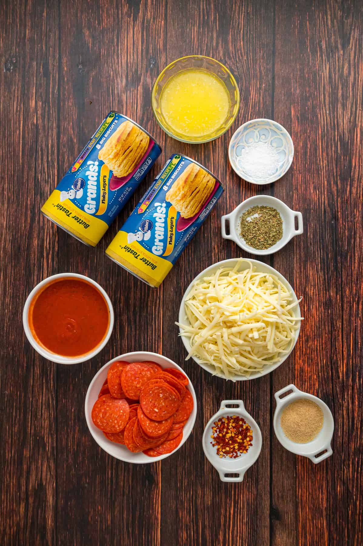 Made with biscuits, mozzarella cheese, and pepperoni, Pizza Pull Apart Bread is both easy to make and fun to eat. Overhead view of ingredients needed to make pizza pull apart bread