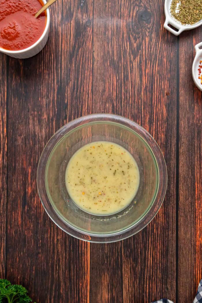 Made with biscuits, mozzarella cheese, and pepperoni, Pizza Pull Apart Bread is both easy to make and fun to eat. A small glass dish of garlic butter