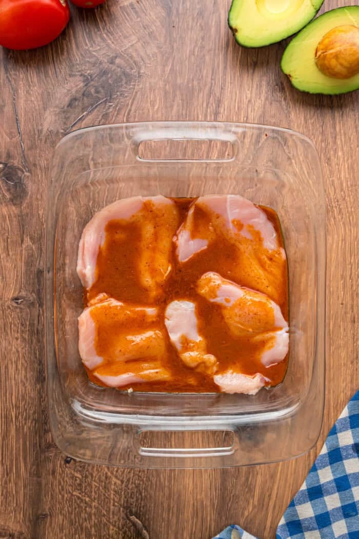 This Southwest Chicken Salad features seasoned chicken, fresh veggies, and a salsa verde dressing over crispy lettuce. Quick & easy! Chicken marinating in taco seasoning