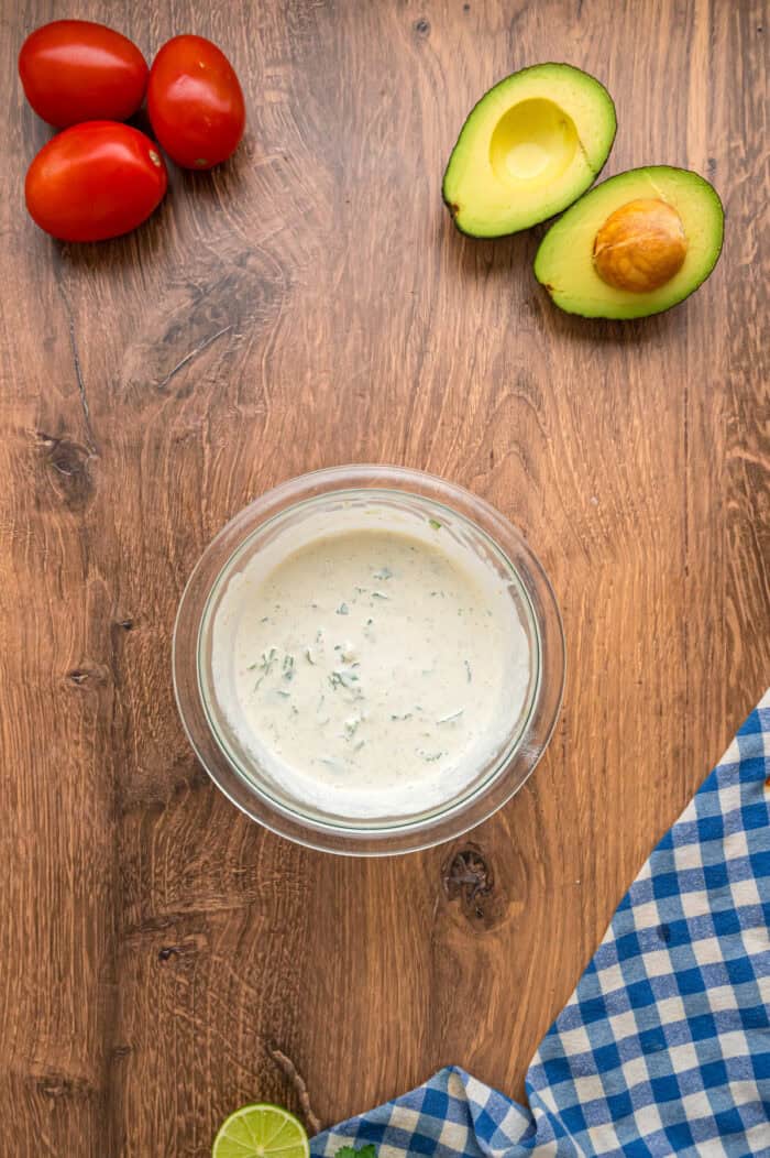This Southwest Chicken Salad features seasoned chicken, fresh veggies, and a salsa verde dressing over crispy lettuce. Quick & easy! Salsa verde dressing in a bowl