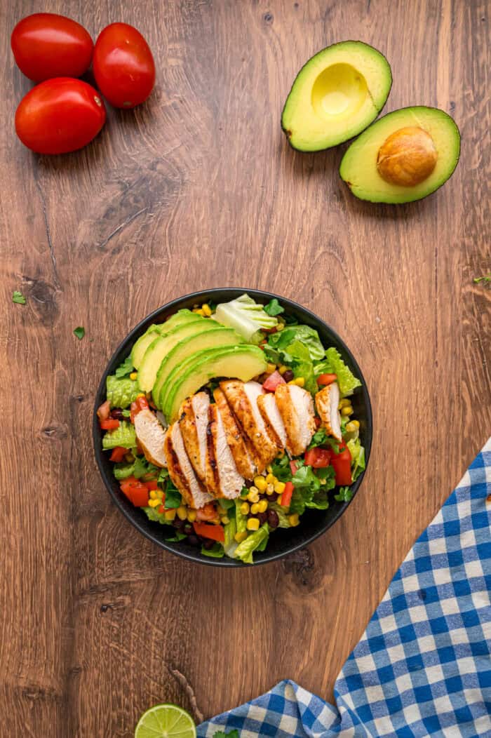 This Southwest Chicken Salad features seasoned chicken, fresh veggies, and a salsa verde dressing over crispy lettuce. Quick & easy! Overhead view of a bowl of southwest chicken salad