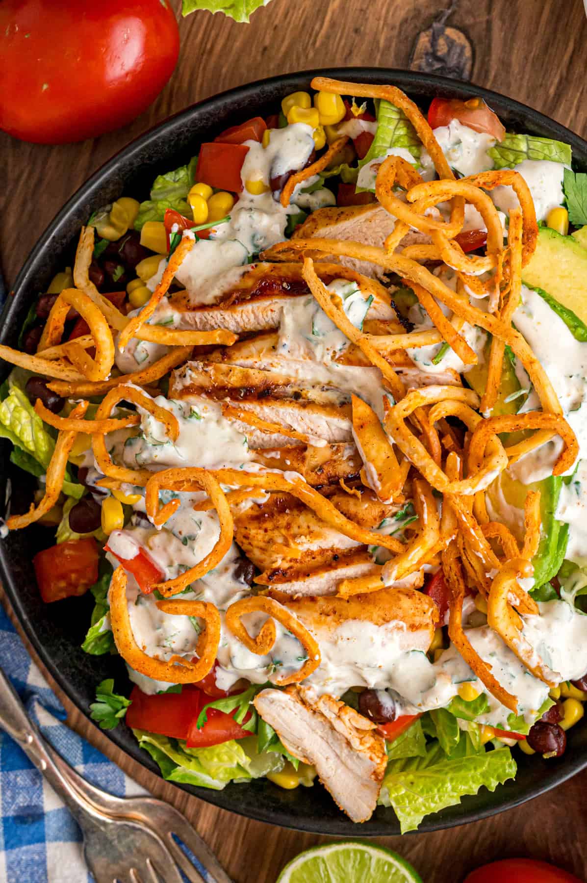 This Southwest Chicken Salad features seasoned chicken, fresh veggies, and a salsa verde dressing over crispy lettuce. Quick & easy! Overhead view of a southwest chicken salad