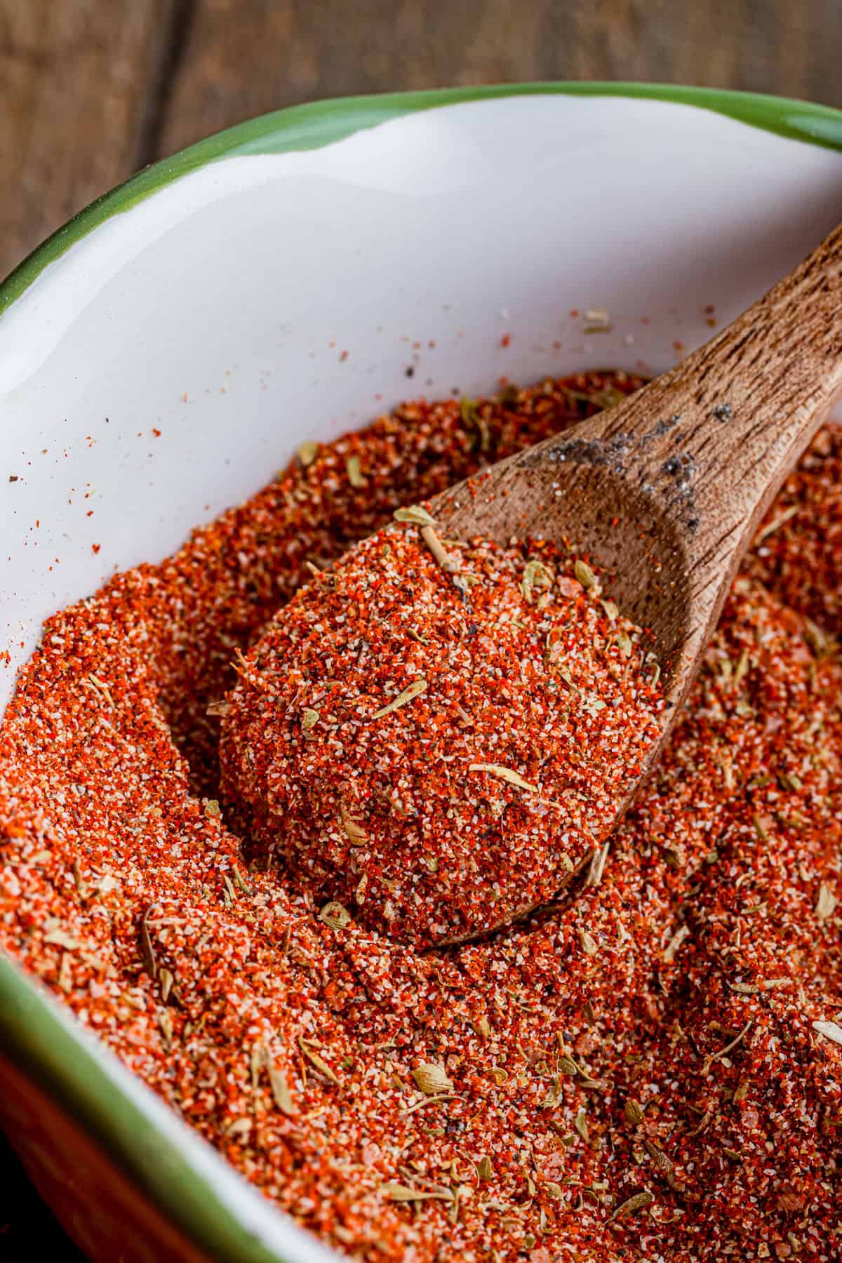 A wooden spoon in a bowl of blackened seasoning