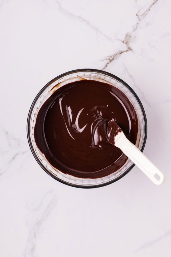 Chocolate Cheesecake Bars are ultra-decadent with three layers of chocolate. Easy to make & great for sharing! Melted chocolate n a bowl