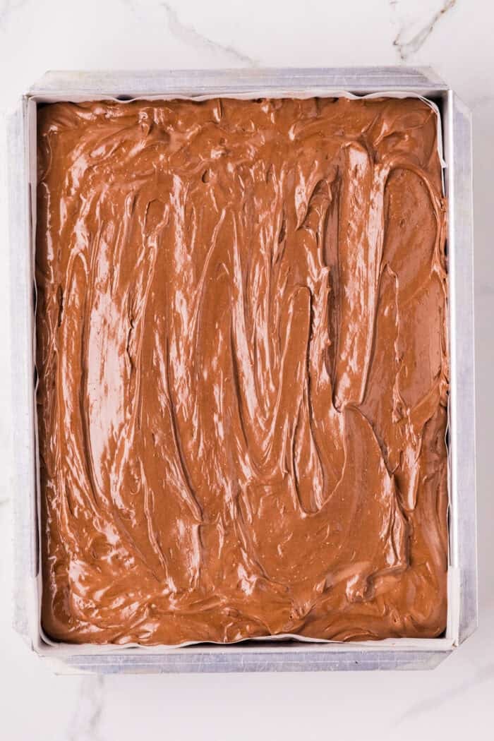 Chocolate Cheesecake Bars are ultra-decadent with three layers of chocolate. Easy to make & great for sharing! Chocolate cheesecake filling in a cake pan