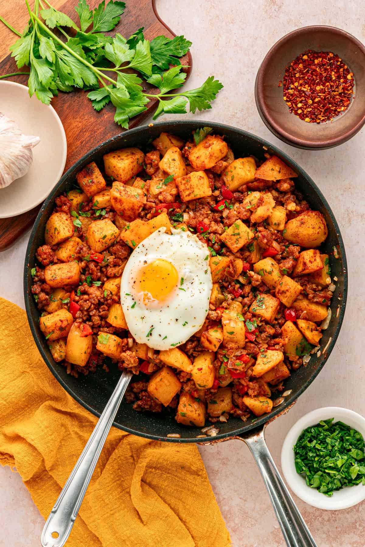 Overhead view of a skillet of papas con chorizo topped with an egg