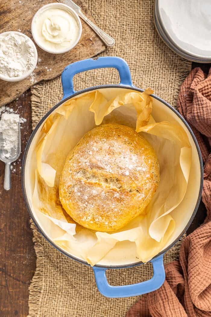 Make a crusty artisan loaf of bread at home with just 10 minutes of prep with this No Knead Dutch Oven Bread recipe. Just 4 ingredients! Overhead view of no knead bread in the Dutch oven after baking