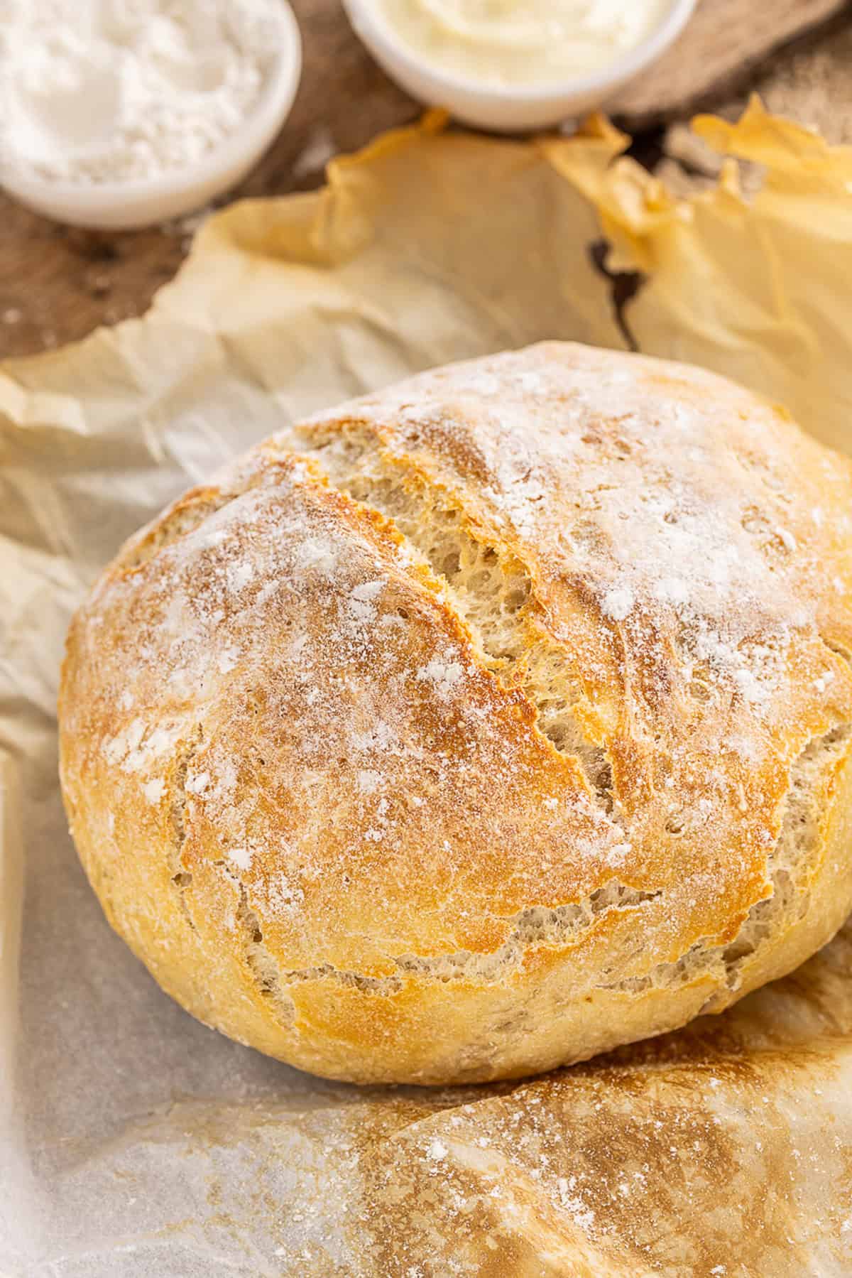 Make a crusty artisan loaf of bread at home with just 10 minutes of prep with this No Knead Dutch Oven Bread recipe. Just 4 ingredients! A loaf of Dutch oven bread on parchment paper