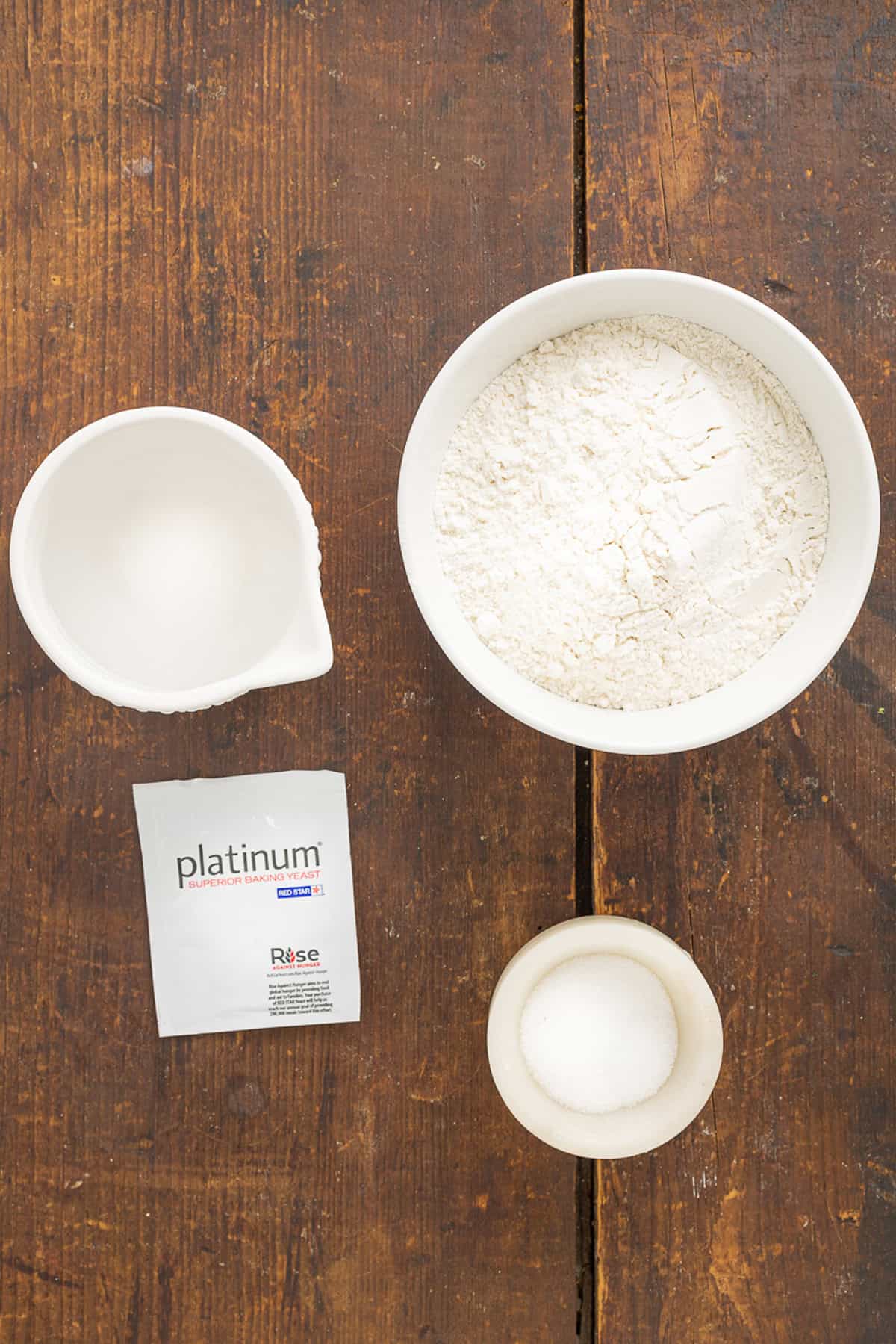 Make a crusty artisan loaf of bread at home with just 10 minutes of prep with this No Knead Dutch Oven Bread recipe. Just 4 ingredients! Overhead view of ingredients needed to make Dutch oven bread