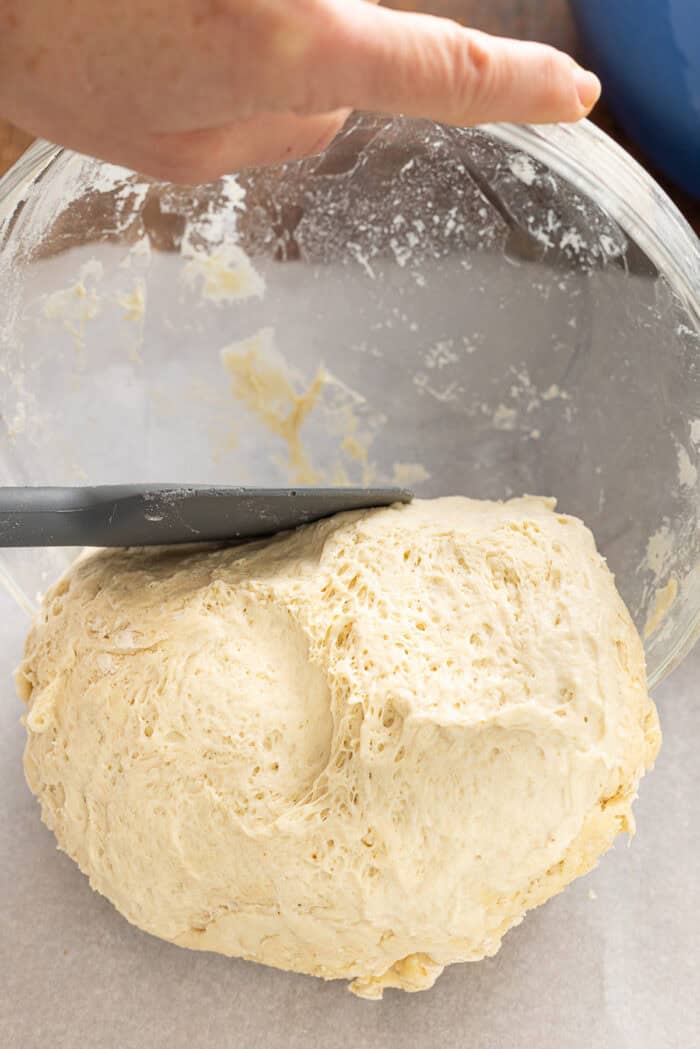 Make a crusty artisan loaf of bread at home with just 10 minutes of prep with this No Knead Dutch Oven Bread recipe. Just 4 ingredients! Shaping a loaf of bread dough