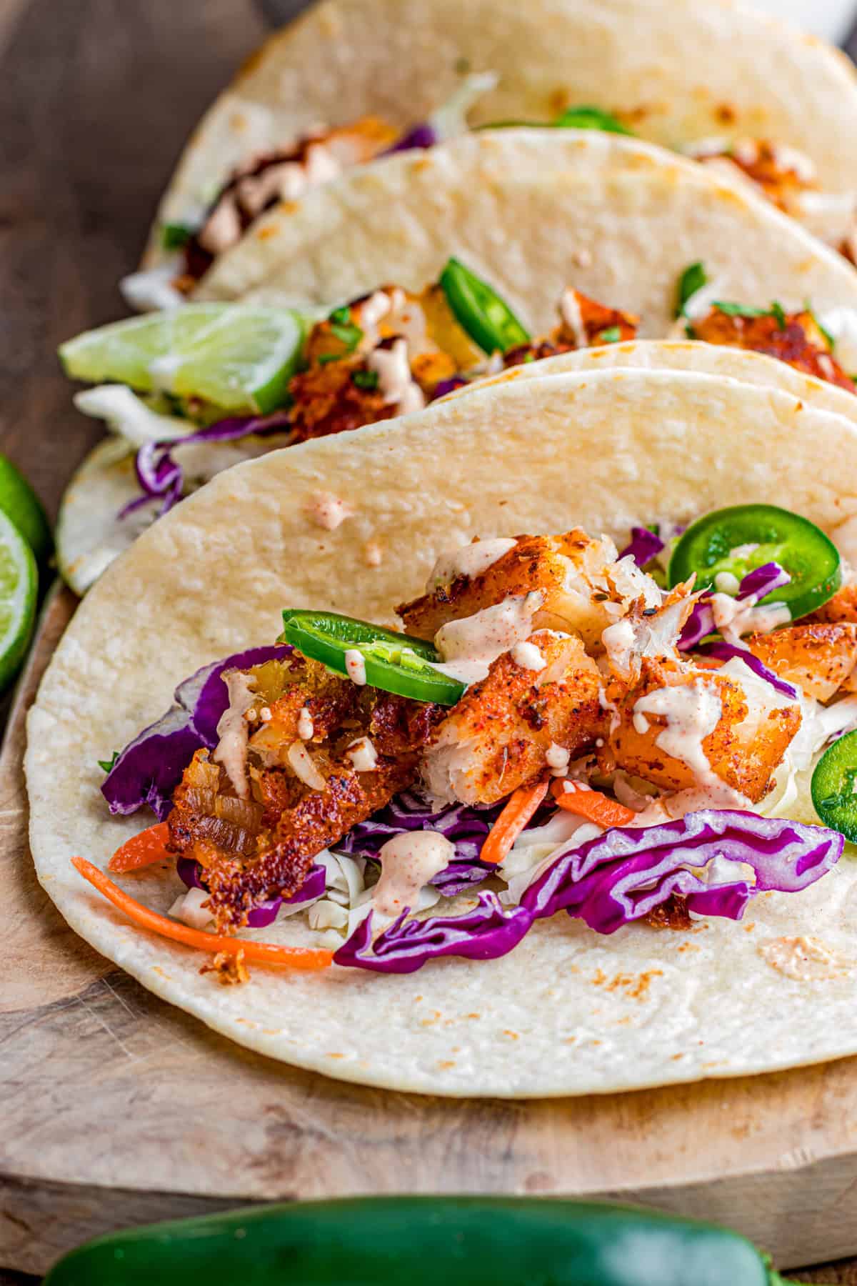 Topped with tangy fish taco sauce, these Blackened Fish Tacos are bold, flavorful, and ready in under 20 minutes. Close up of blackened fish tacos