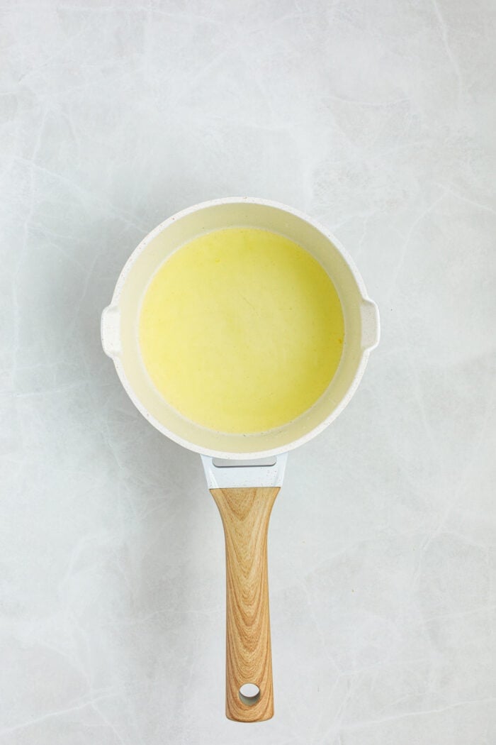 This Limoncello Mascarpone Cake begins with a moist lemon cake topped with limoncello syrup, mascarpone cream, and lemon curd. Limoncello syrup in a saucepan