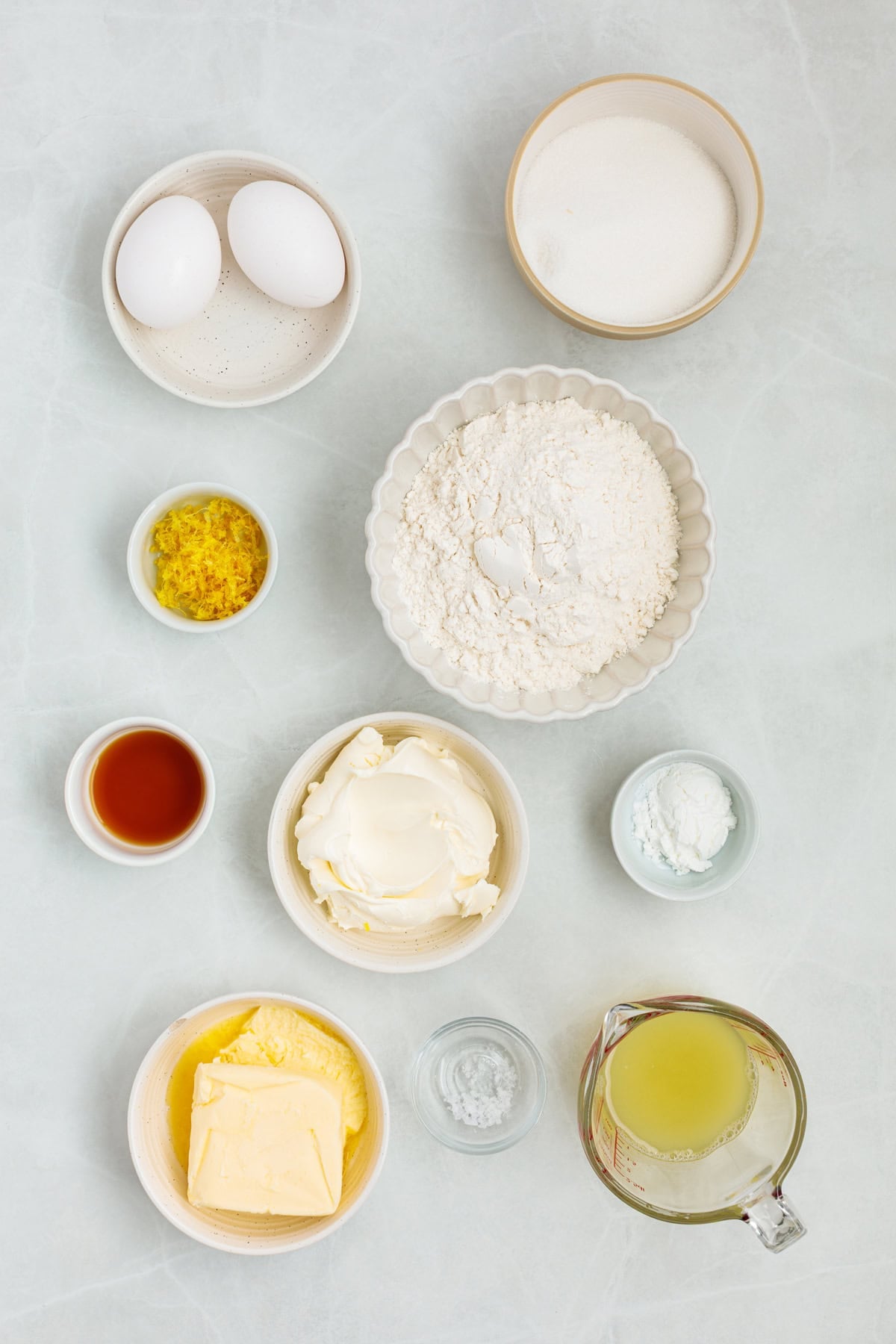 This Limoncello Mascarpone Cake begins with a moist lemon cake topped with limoncello syrup, mascarpone cream, and lemon curd. Overhead view of ingredients needed to make lemon cake