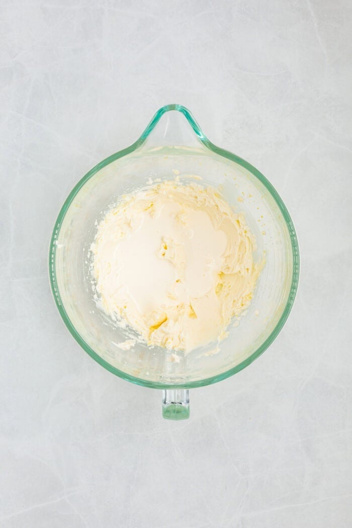 This Limoncello Mascarpone Cake begins with a moist lemon cake topped with limoncello syrup, mascarpone cream, and lemon curd. Mascarpone cream in a bowl