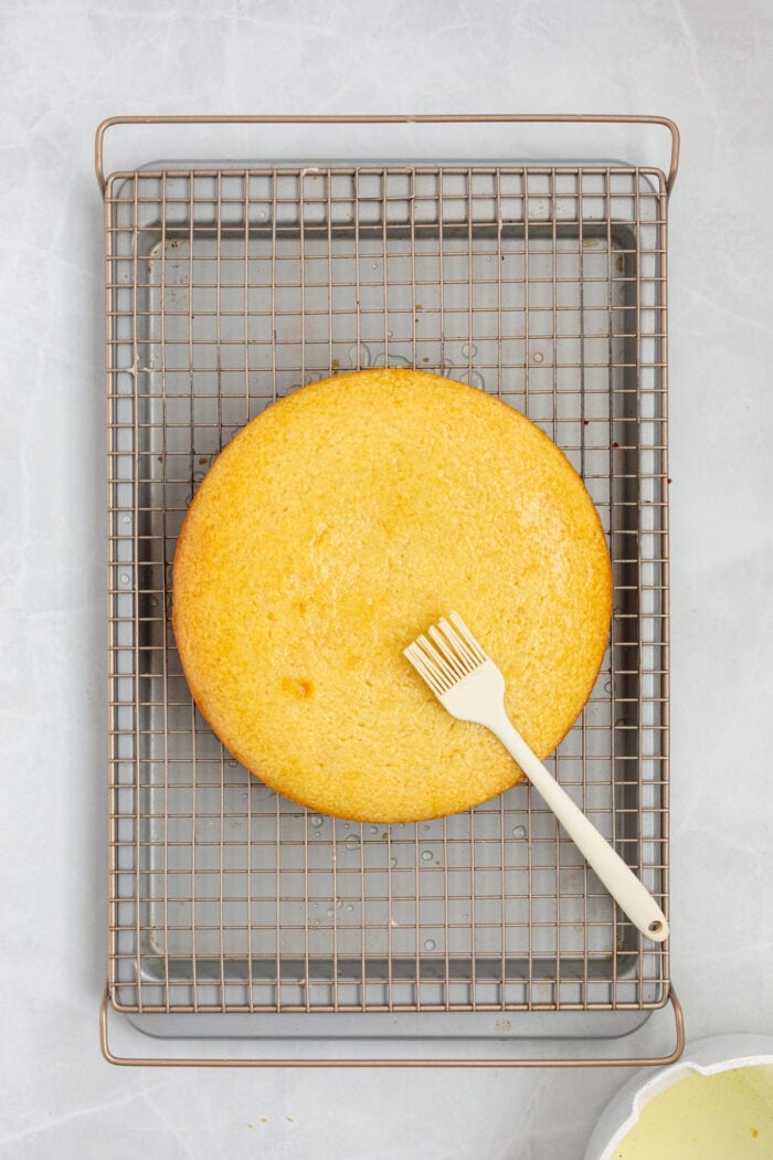 This Limoncello Mascarpone Cake begins with a moist lemon cake topped with limoncello syrup, mascarpone cream, and lemon curd. Brushing limoncello syrup over a cake
