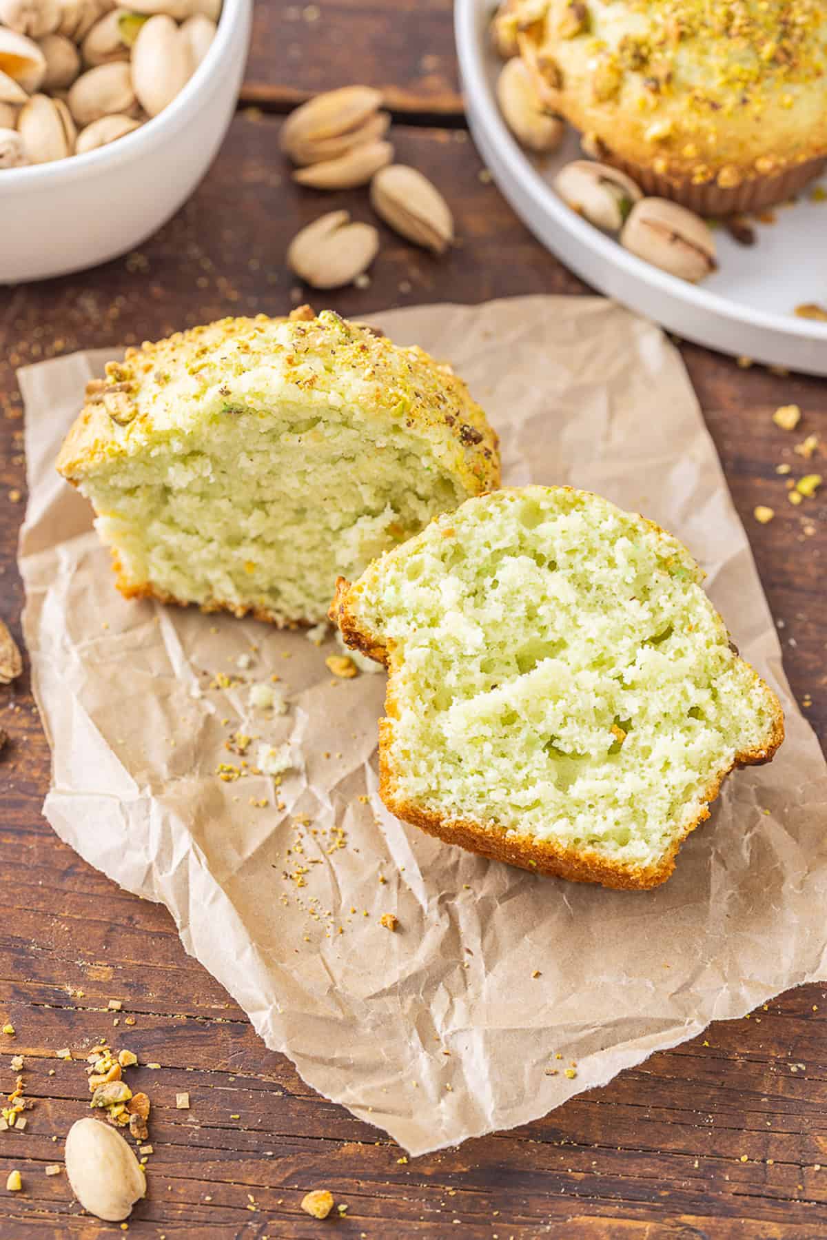 With tall bakery-style domes, these Pistachio Muffins are tender and moist with a lovely pistachio flavor. Quick & easy! A pistachio muffin cut in half on a napkin