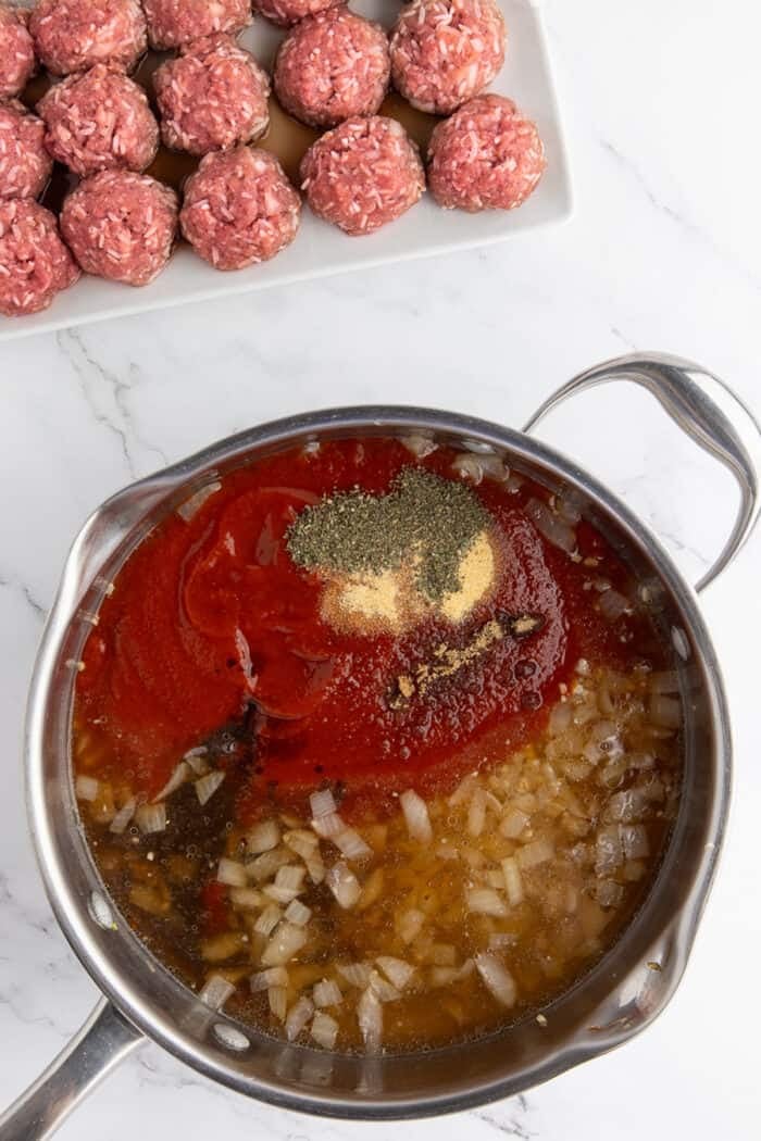 Tomato sauce ingredients added to the pan