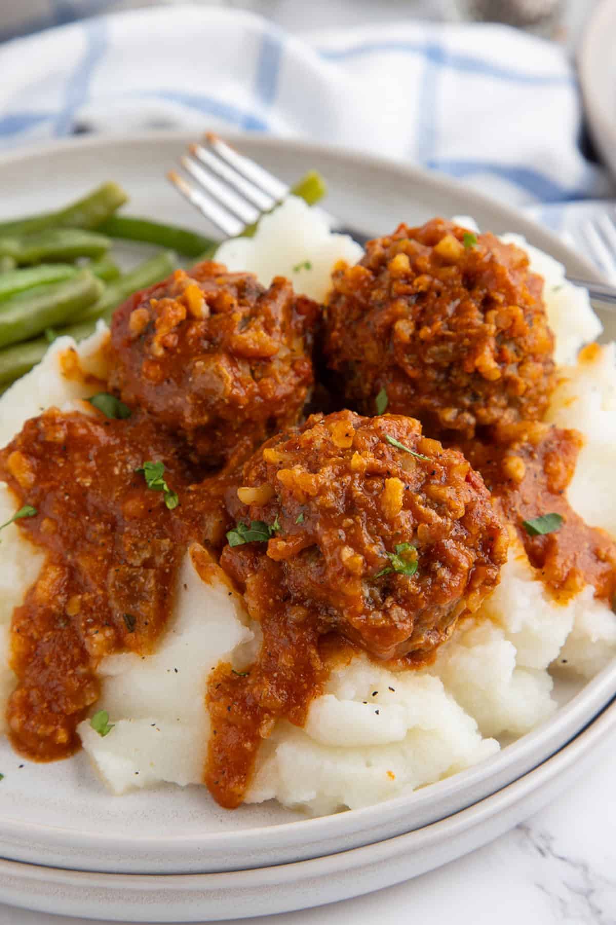 A plate of porcupine meatballs over mashed potatoes