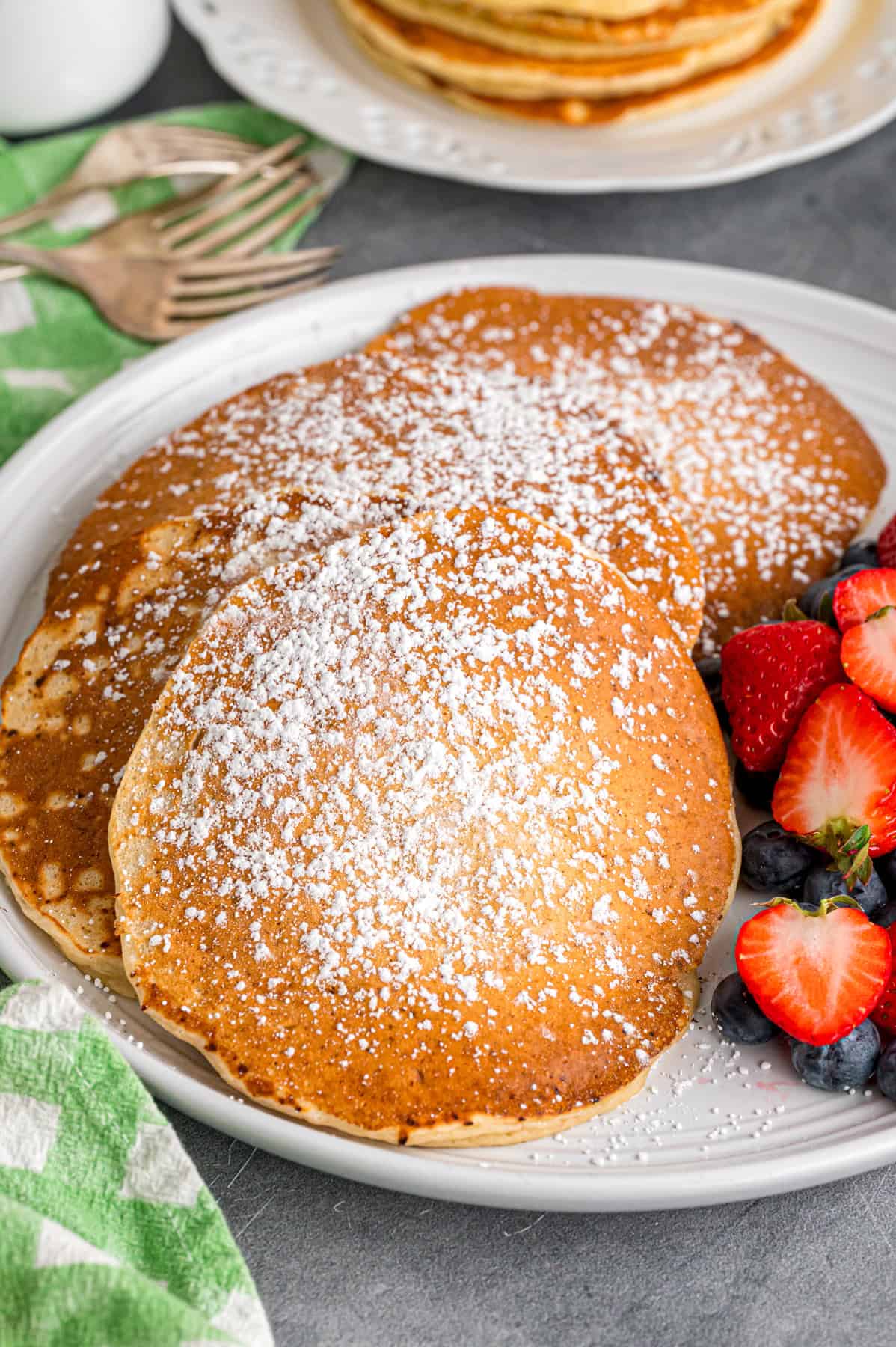 Made with just a handful of ingredients, these Cottage Cheese Pancakes are soft and filling with a lightly sweet flavor. A plate of cottage cheese pancakes dusted with powdered sugar