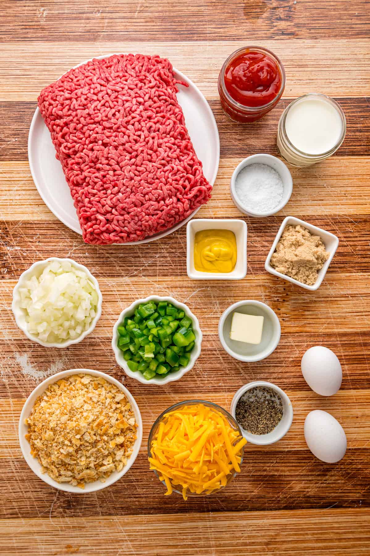 Shredded cheddar, sauteed onions and bell peppers, and Ritz cracker crumbs make this Cracker Barrel Meatloaf extra moist and flavorful. Overhead view of the ingredients needed to make Cracker Barrel meatloaf