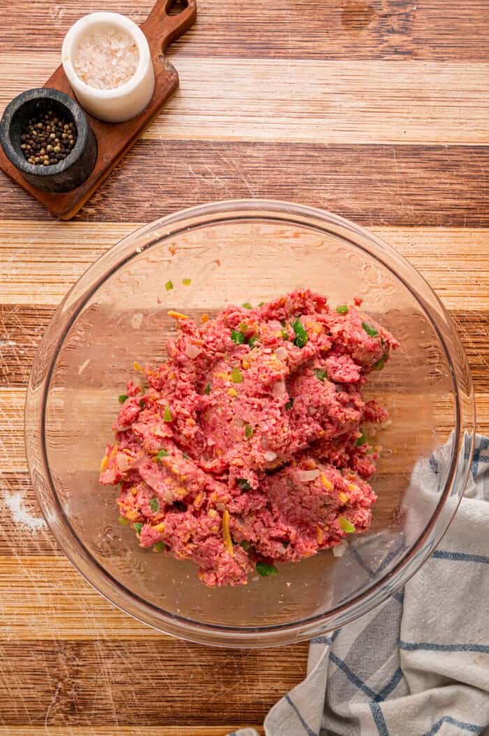 Shredded cheddar, sauteed onions and bell peppers, and Ritz cracker crumbs make this Cracker Barrel Meatloaf extra moist and flavorful. Meatloaf mixture in a bowl