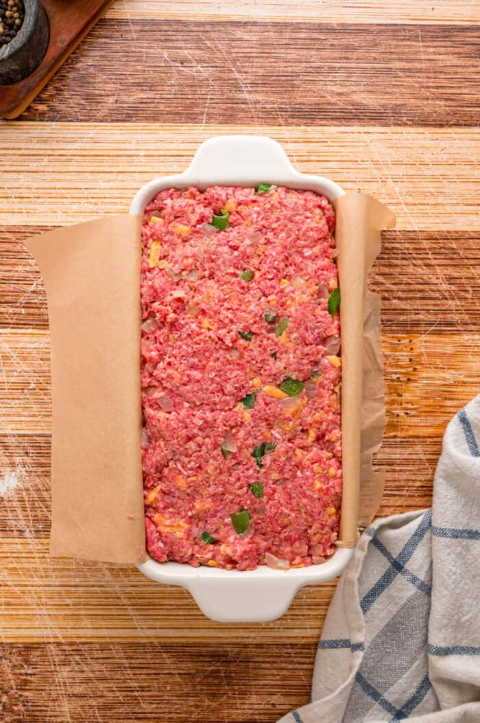Shredded cheddar, sauteed onions and bell peppers, and Ritz cracker crumbs make this Cracker Barrel Meatloaf extra moist and flavorful. Meatloaf in a loaf pan