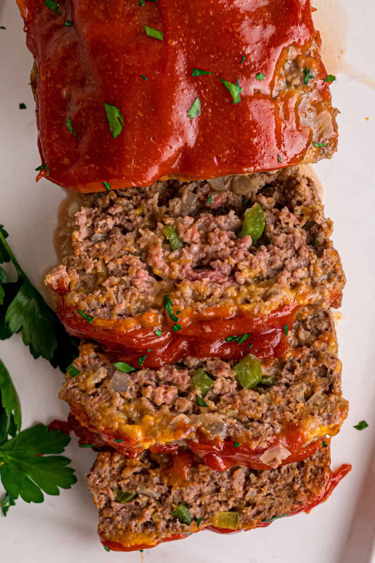 Shredded cheddar, sauteed onions and bell peppers, and Ritz cracker crumbs make this Cracker Barrel Meatloaf extra moist and flavorful. Cracker Barrel Meatloaf cut into slices