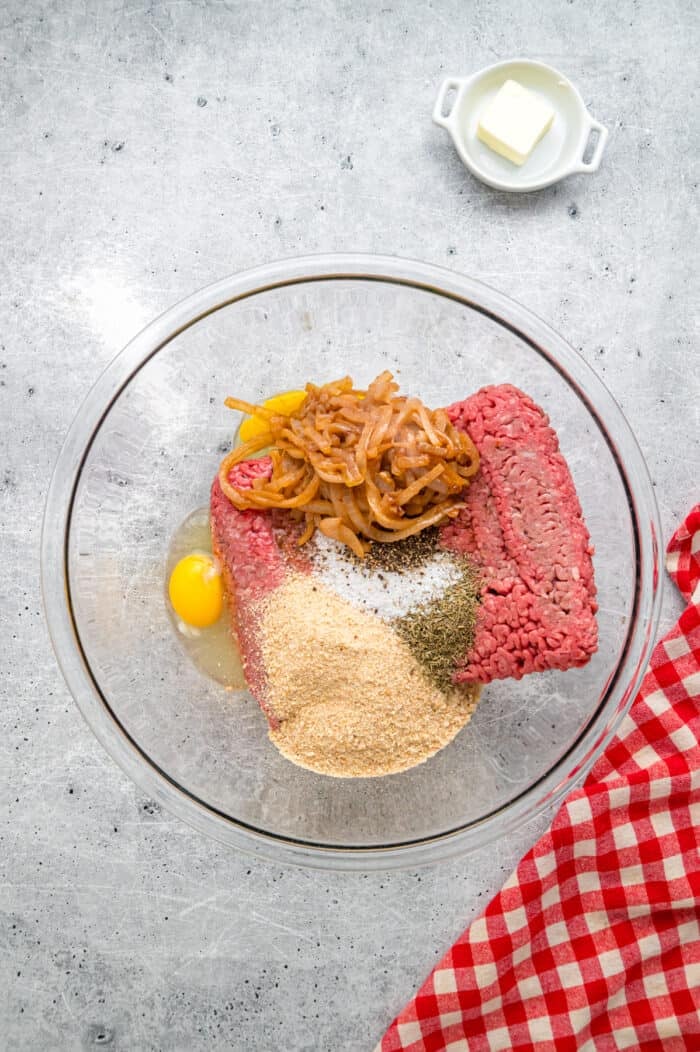 Caramelized onions, a savory onion sauce, and gooey, cheese turn basic meatloaf into an elevated dinner in this French Onion Meatloaf recipe. Ground beef, caramelized onions, breadcrumbs, egg, and seasonings in a bowl