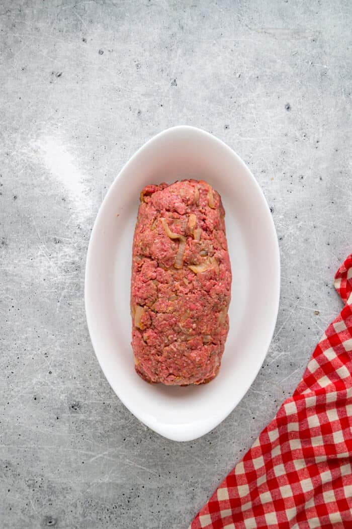Caramelized onions, a savory onion sauce, and gooey, cheese turn basic meatloaf into an elevated dinner in this French Onion Meatloaf recipe. Unbaked meatloaf in a baking dish