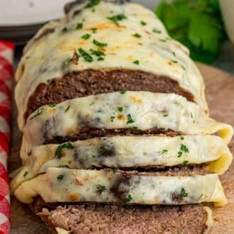 Front view of French onion meatloaf with several pieces sliced