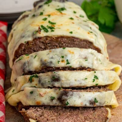 Front view of French onion meatloaf with several pieces sliced