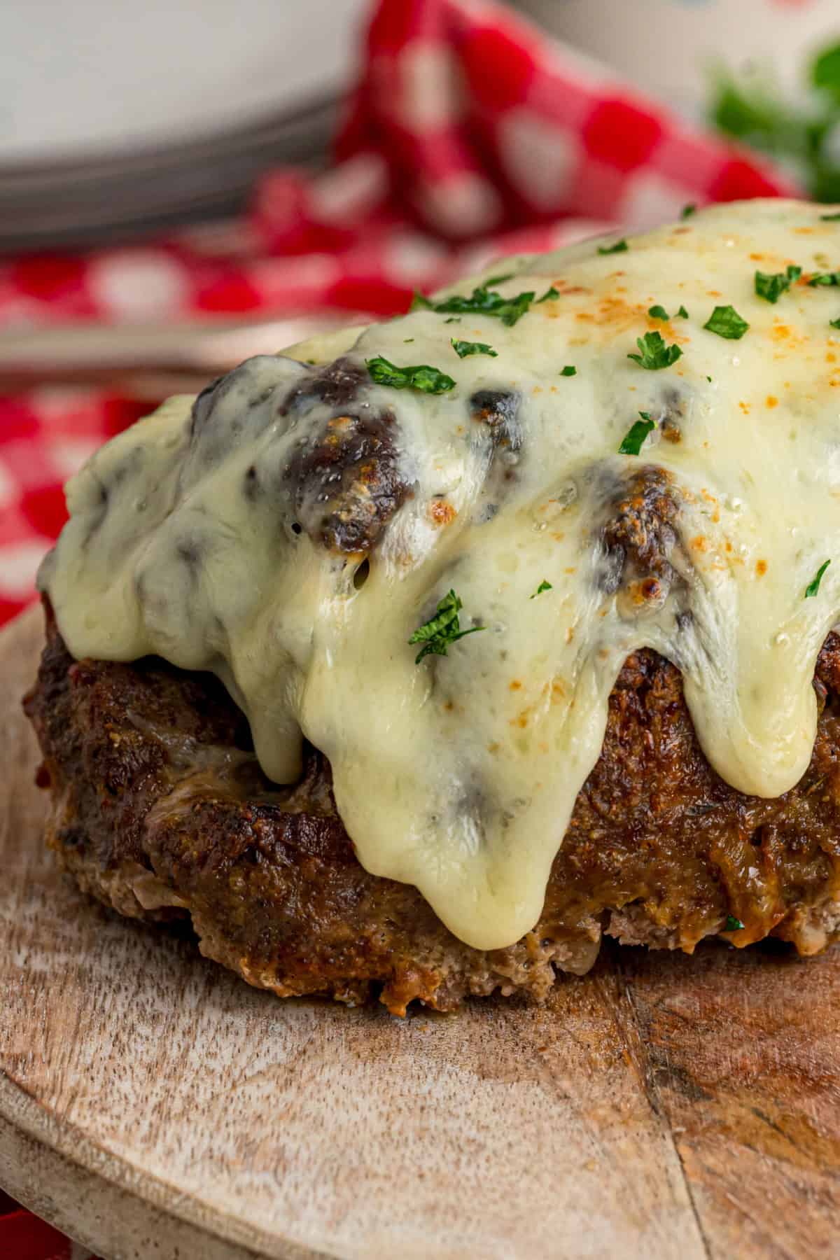Caramelized onions, a savory onion sauce, and gooey, cheese turn basic meatloaf into an elevated dinner in this French Onion Meatloaf recipe. close up side view of French Onion Meatloaf