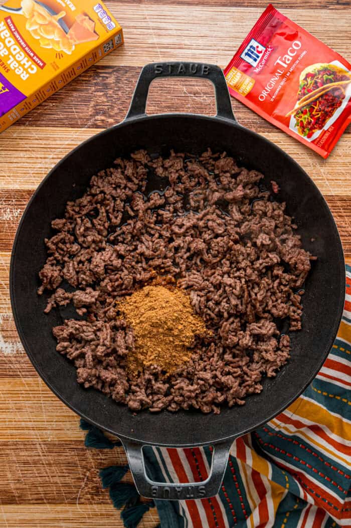 Taco seasoning added to browned ground beef in a skillet