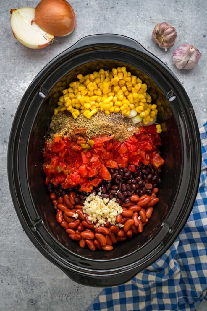 Beans, corn, Rotel, diced tomatoes, and spices in a slow cooker.