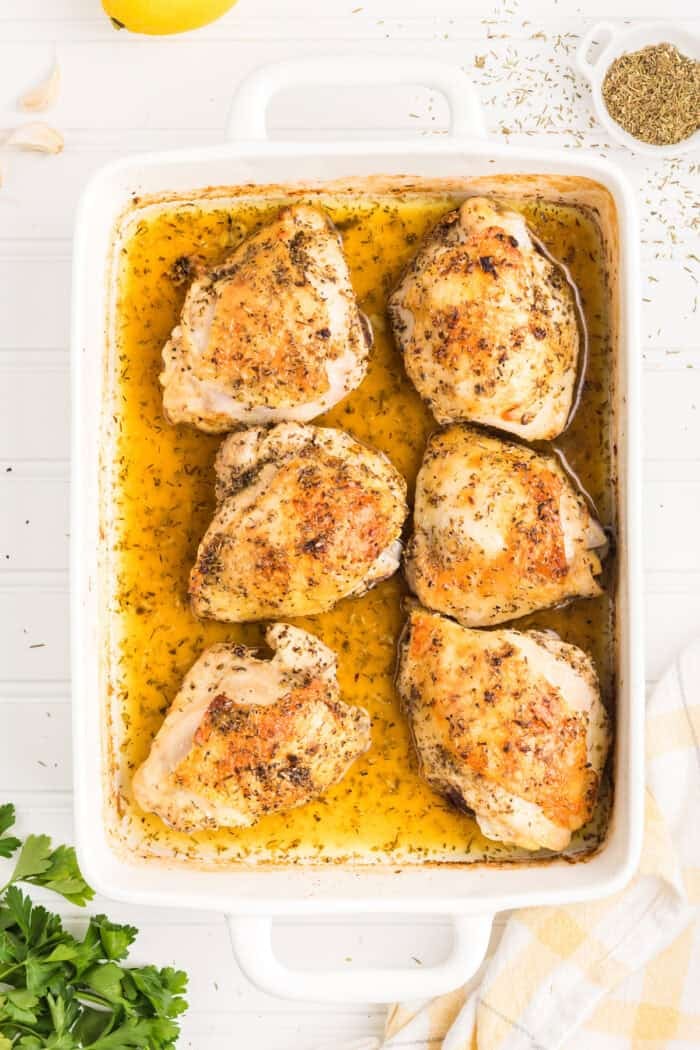 Overhead view of baked lemon chicken in a baking dish
