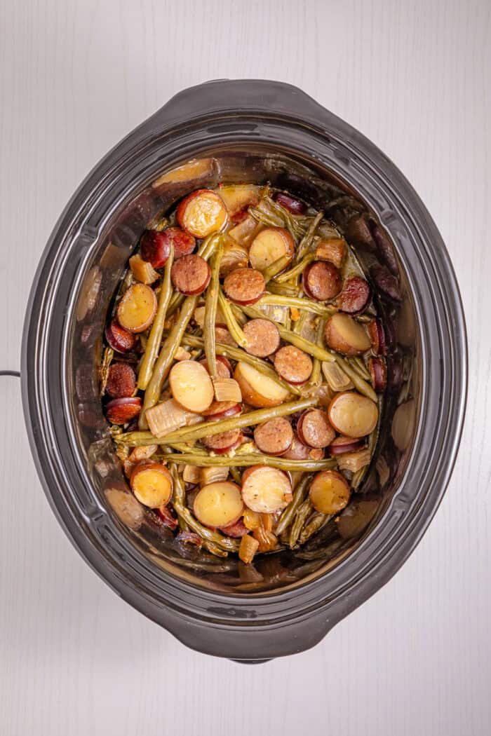 Baby potatoes, smoked sausage, and green beans are slow-cooked in Cajun seasoning and cream of chicken soup in this Crockpot Swamp Potatoes recipe. It’s an easy, flavorful dump-and-go recipe that’s perfect for busy weekends. Baby potatoes, sausage, and green beans in a crockpot