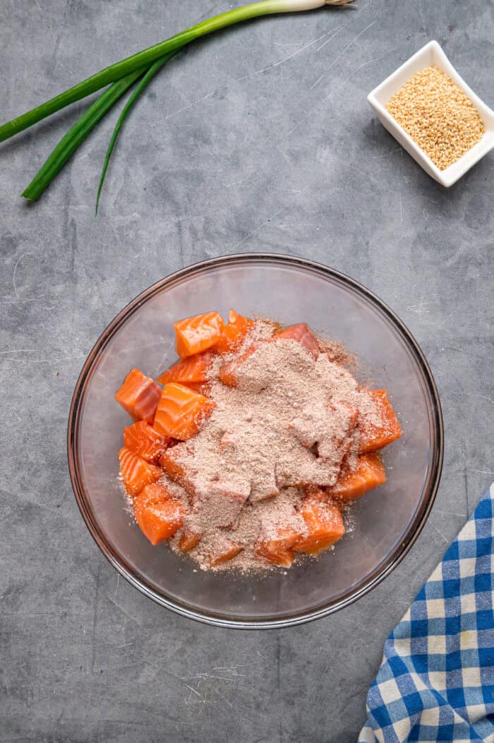 Brown sugar seasoning mixed on top of pieces of salmon in a bowl