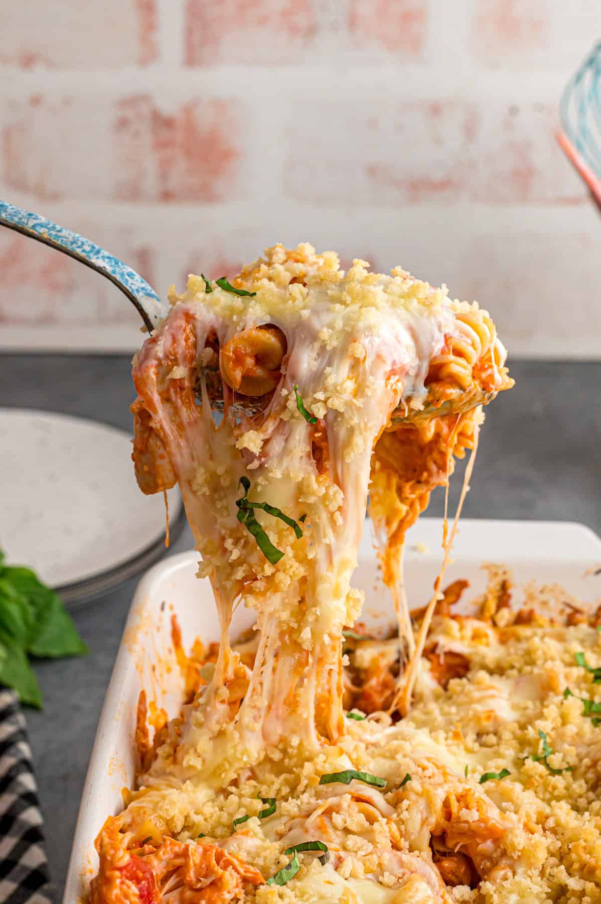 A spoon serving chicken parmesan casserole