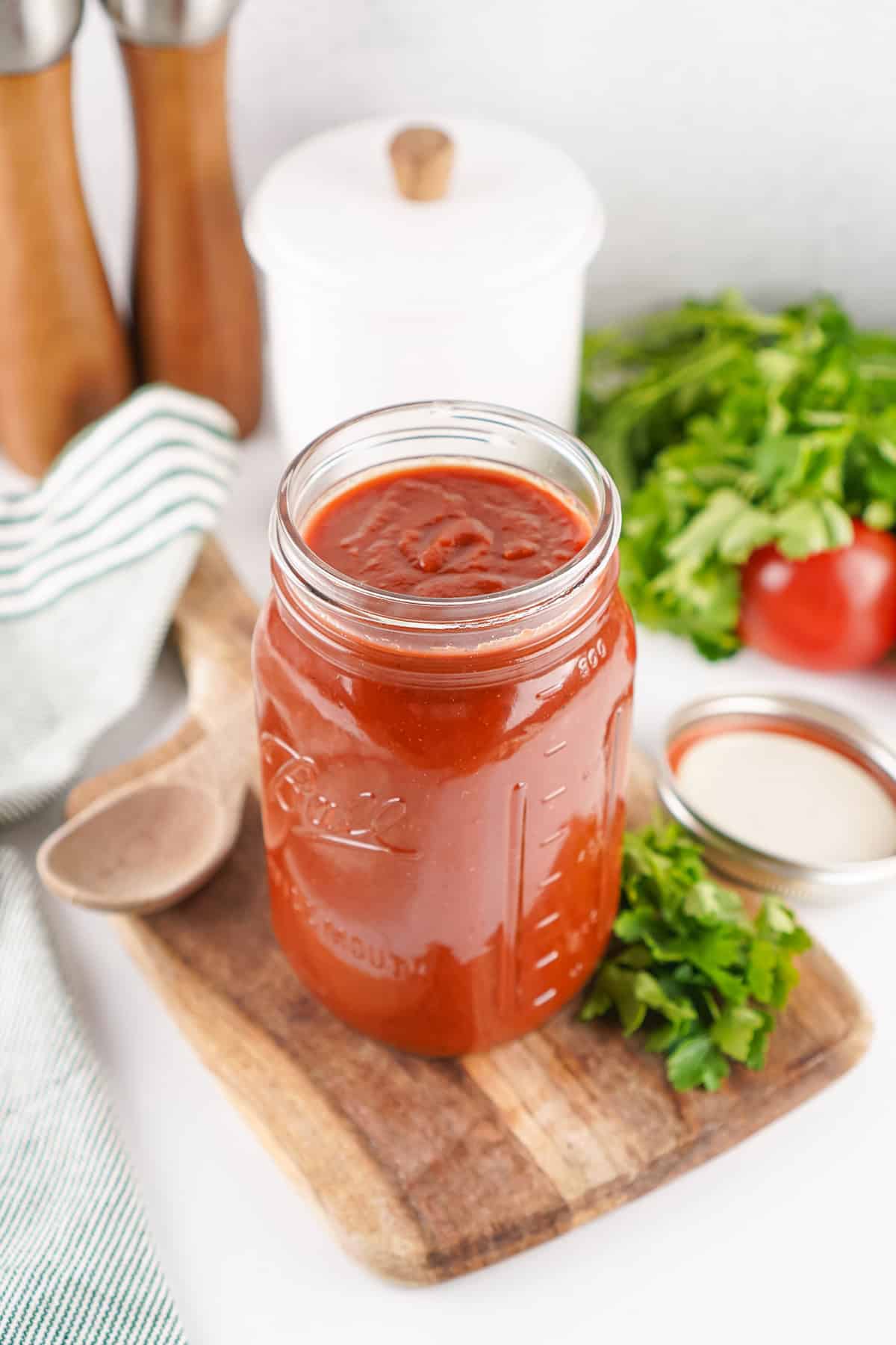 It only takes a handful of ingredients and a bit of simmering to make Homemade Ketchup that's far better than store-bought. Angled overhead view of a jar of homemade ketchup
