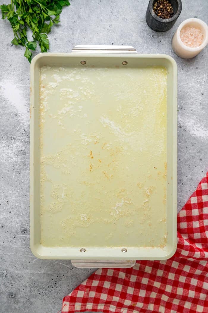 Coated in seasoned panko breadcrumbs, this oven fried chicken is crispy on the outside and juicy on the inside. Quick & easy! Melted butter on a baking sheet