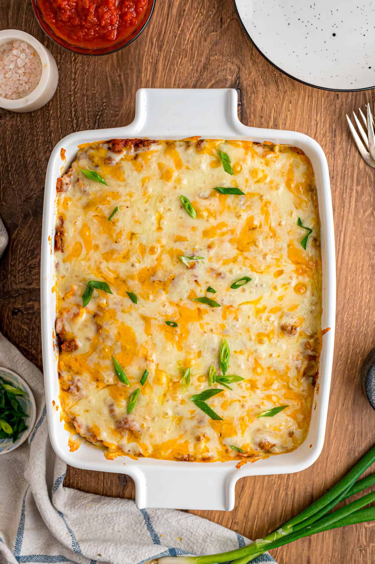 With noodles coated in sour cream, meat sauce, and lots of cheese, this sour cream noodle bake is quick, easy & comforting. Overhead view of baked sour cream noodle bake