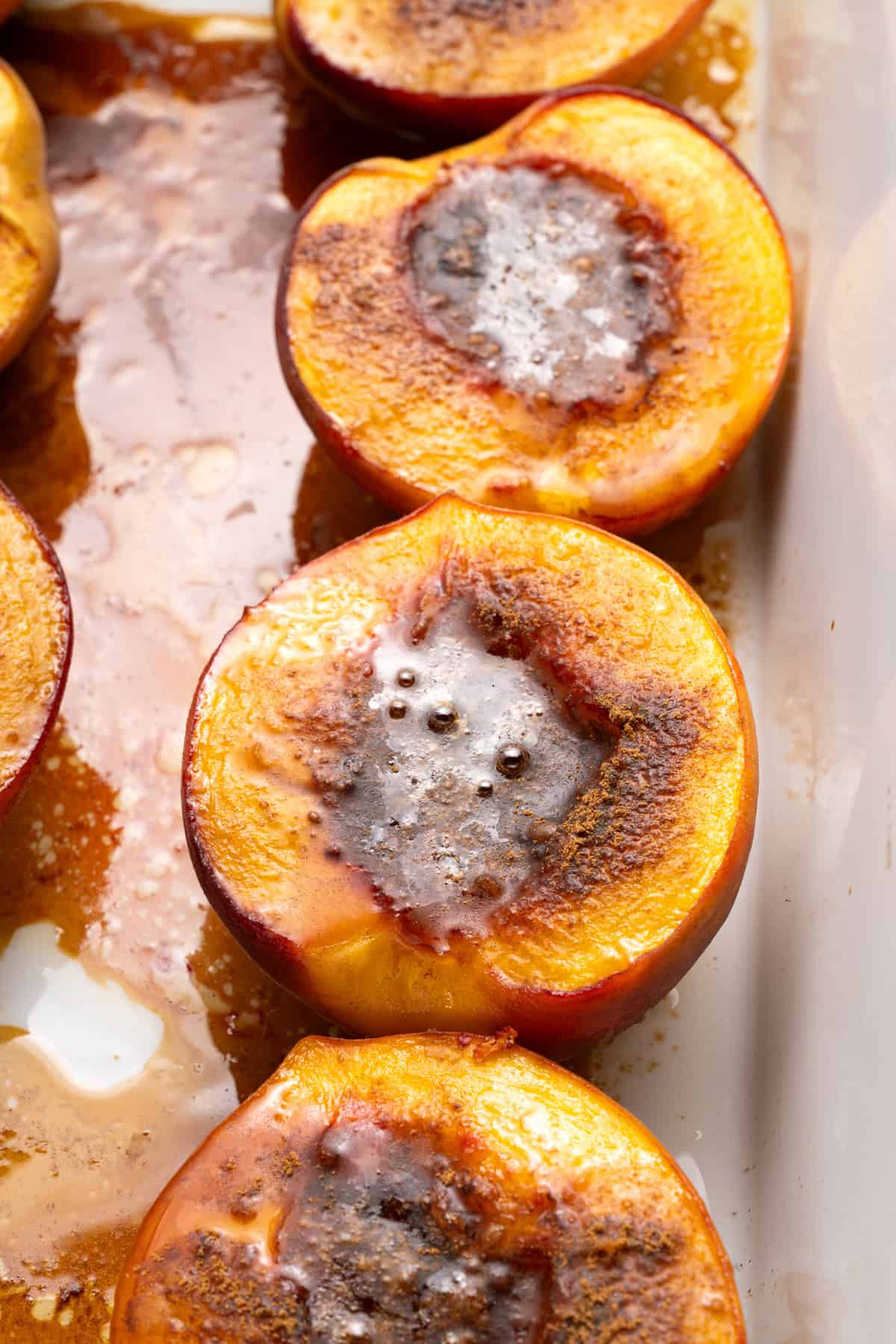 Overhead view of baked peaches in a pan