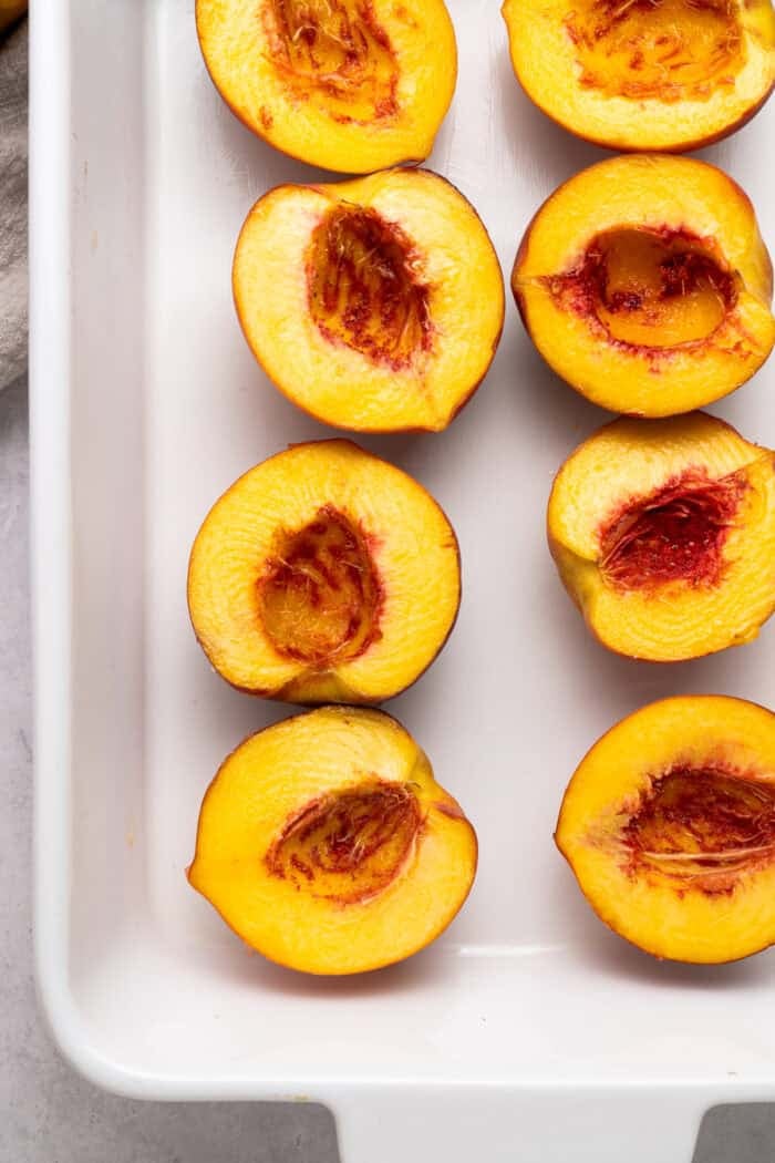 Peach halves in a baking pan